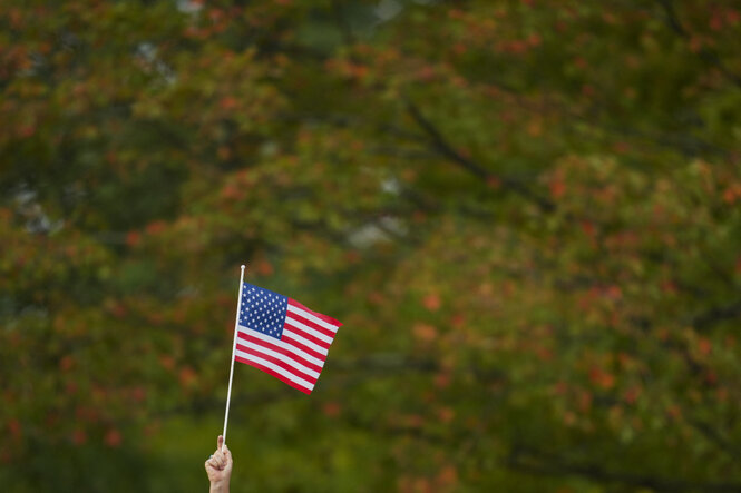 Eine Hand hält eine amerikanische Flagge