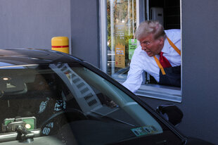 Donald Trump händigt Fast Food aus dem Fenster eines McDonalds aus