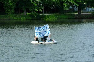 Menschen im Schlauchboot mit Parole 