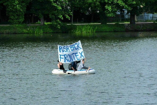 Menschen im Schlauchboot mit Parole "Push back Frontex"