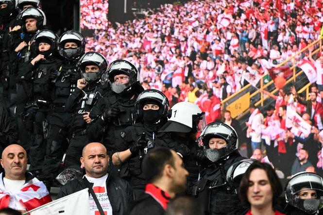 Behelmte Polizisten im Stadion, die auf den Rängen postiert sind