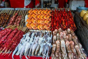 Geröstete und rohe Insekten, Seidenraupen, Skorpione, Käfer, Garnelen, Krabben, Langusten, Schlangen, Hundefleisch, am Stiel an einem Marktstand