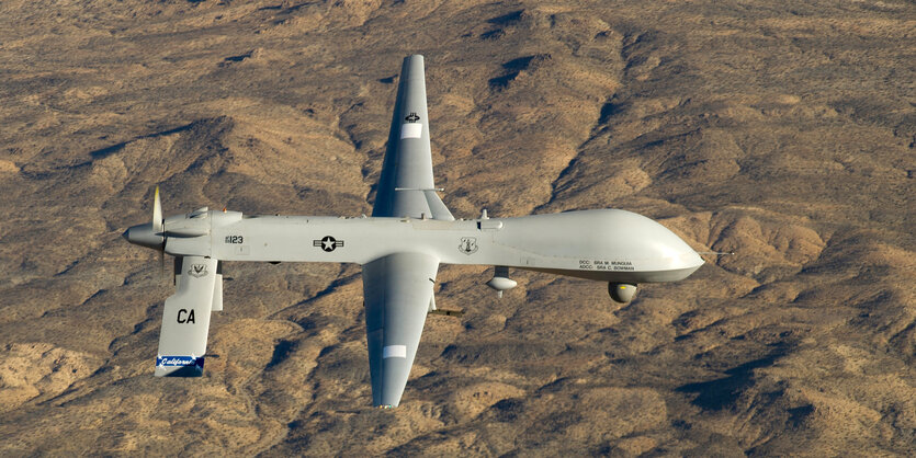 Militärdrohne fliegt über karger Landschaft