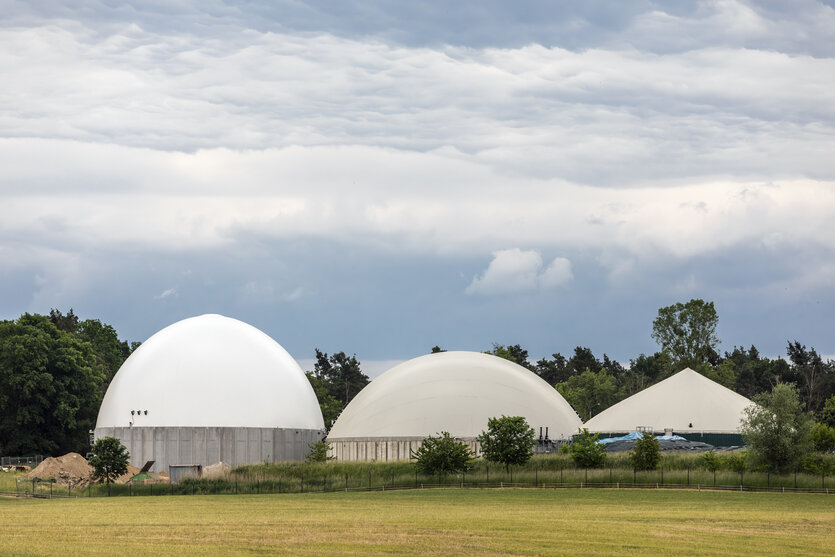 Biogasanlage mit 3 charakteristischen Fermentern - kugelige Gebäude auf einer Wiese