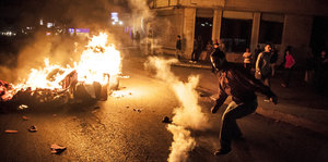Ein Demonstrant in Istanbul kickt eine Tränengaskartusche der Polizei weg.