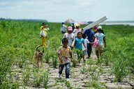 Angehörige der indigenen Tikuna-Gemeinschaft gehen in Loma Linda, einem Außenbezirk von Leticia, Kolumbien, in der Nähe des Amazonasflusses, um Hilfe von einer NRO zu erhalten.