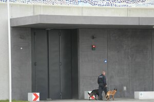 Ein Justizangehöriger geht mit zwei Hunden vor der Justizvollzugsanstalt Augsburg-Gablingen