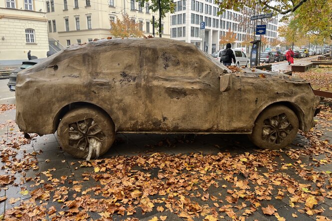 Ein schon angeranzter SUV von Folke Köbberling, umgeben von Herbstlaub