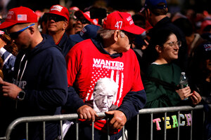 Ein Mann trägt eine rote Kappe und ein T-Shirt mit dem Konterfei von Donald Trump