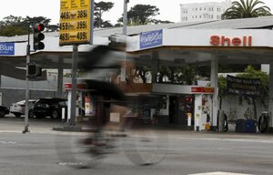 Ein Radfahrer fährt an einer Shell-Tankstelle vorbei
