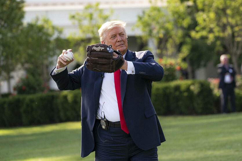 Donald Trump im Anzug wirft einen Baseball