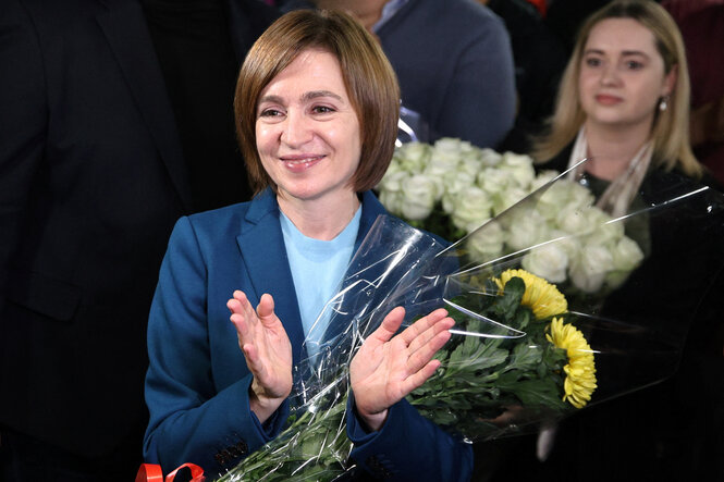 Maia Sandu mit Blumen im Arm klatscht