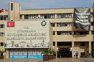 Am Gebäude der Regionaverwaltung von Diyarbakir hängt ein Plakat mit der Aufschrift "Die Gemeinden gehören uns, wir werden keine Usurpation zulassen"