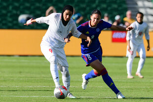 Zahra Ghanbari tritt von einer Gegnerin bedrängt gegen den Ball