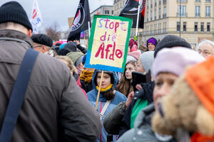 Demonstration, eine junge Teilnehmende hält ein Schild 