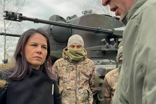 Annalena Baerbock steht mit Soldaten vor einem Gepard-Panzer