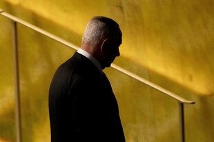 Ministerpräsident Benjamin Netanjahu bei einer Veranstaltung. Er geht eine Treppe runter. Man sieht seinen Rücken und seinen Kopf sehr dunkel. Der Hintergrund ist gold-gelb.