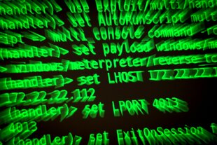 Buchstaben und Zahlen leuchten auf einem Bildschirm, auf dem ein Hacker-Programm geöffnet ist