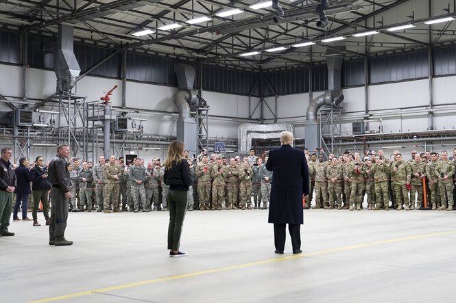 Trump steht in einer Halle vor amerikanischen Soldaten