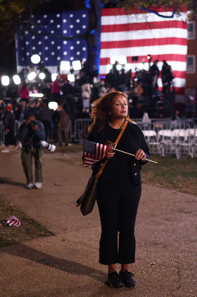 Eine Frau hält mit geschlossenen Augen eine kleine US Flagge