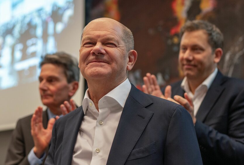 Olaf Scholz vor Deutschland- und EU-Flaggen