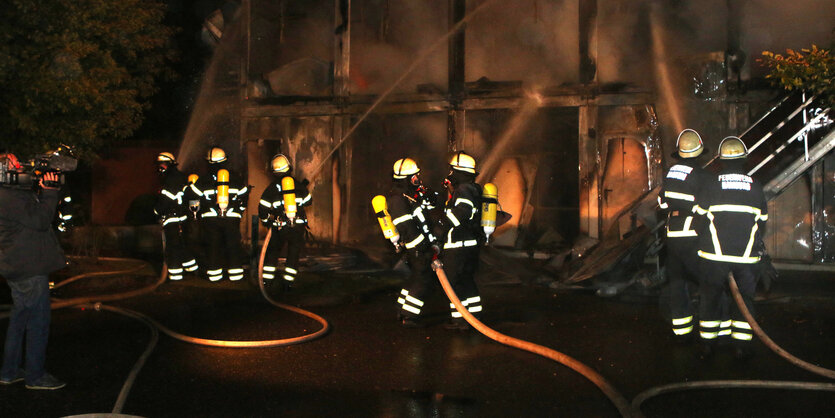 Nur noch die Rahmen der Container stehen. Die Feuerwehr löscht