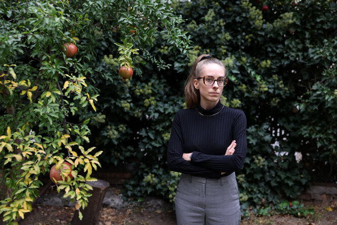 Eine Frau steht vor einem Granatapfel-Baum