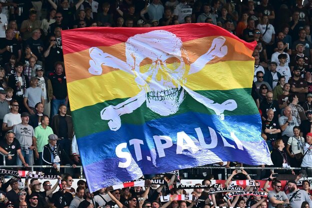 Eine Regenbogenfahne in einem Fußballstadion auf der Tribühne.