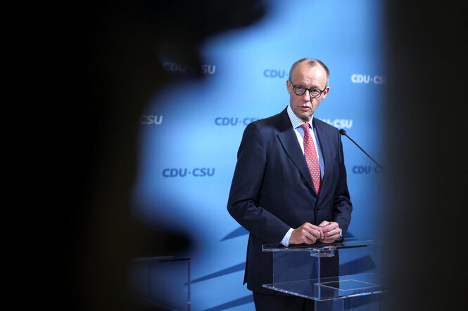 Porträt von Friedrich Merz, der am Rednerpult steht