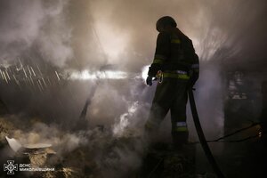 Ein Feuerwehrmann vor Trümmern inmitten von Rauch oder Staub