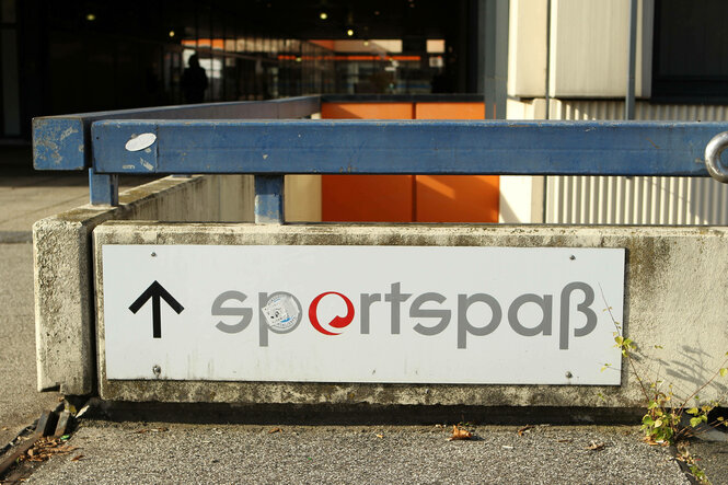 Schild mit der Aufschrift "sportspaß" an einer Außenfassade.