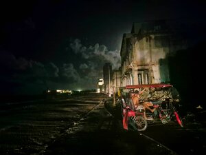 Während eines inselweiten Stromausfalls auf Kuba sitzen zwei Männer in einem Fahrradtaxi