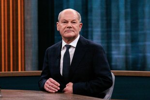 Olaf Scholz sitzt an einem Tisch