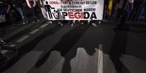 Menschen halten Pegida-Banner
