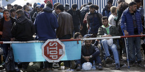 Flüchtlinge stehen, sitzen und warten