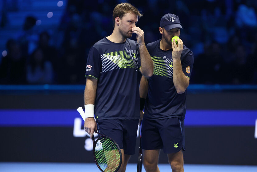 Kevin Krawietz und Tim Puetz fassen sich beide auf dem Tennisplatz an die Nase