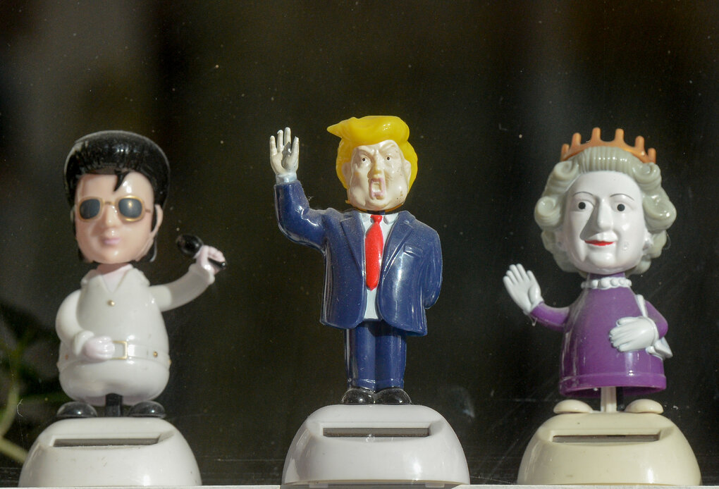 Wackelfiguren von Elvis, Donald Trump und Queen Elisabeth II. stehen mit einem wackelnden erhobenen Arm in einem Geschäft in Berlin.