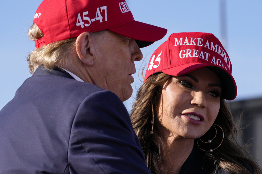 Ein Mann und eine Frau haben rote Basecaps auf mit dem Schriftzug "Make Amerika great again"