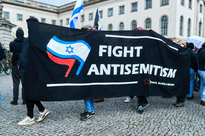 Protestierende halten ein banner mit der Aufschrift: "Fight Antisemitism"