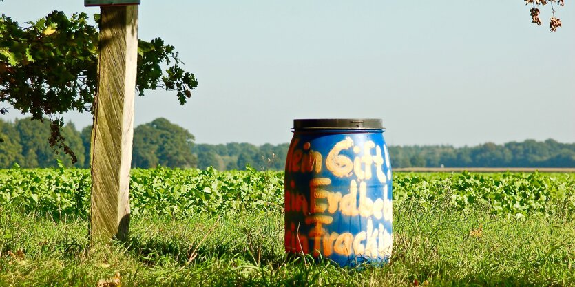 Fass mit gelbem Anti-Fracking Schriftzug auf einer Wiese