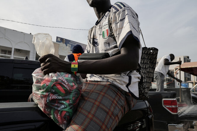 Ein Anhänger des senegalesischen Premierministers und Vorsitzenden der regierenden Pastef-Partei, Ousmane Sonko, hält eine Plastiktüte mit Wahlkampfarmbändern in der Hand