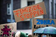 Bei einer Demonstration gegen Gewalt an Frauen hält eine Teilnehmerin ein Plakat mit der Aufschrift «Femizide stoppen»