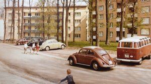 VW Käfer und VW Bulli parken vor einer Wohnanlage, Kinder spielen. Das Bild zeigt die Waldsiedlung im Wolfsburger Stadtteil Hellwinkel in den 1960er Jahren.