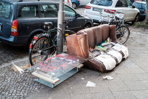 Ein braunes Sofa und Müll an den Berliner Straßen