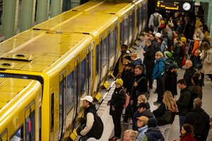 Eine U-Bahn in Berlin, vor der viele Menschen warten