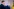 Christian Lindner steht im Vordergrund nahe bei einer deutschen Fahne, die ins Bild reinragt. Er fasst sich an die Nase. Im Hintergrund sieht man Olaf Scholz