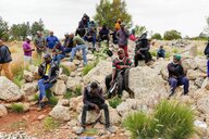 Erschöpfte Männer sitzen auf Felsen