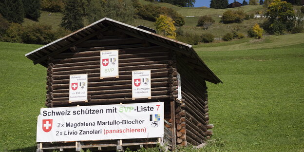 Eine Hütte mit Wahlwerbung für die rechtspopulistische SVP auf einem verlassenen, saftig grünen Hügel