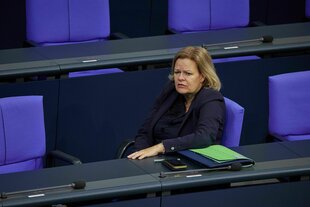 Nancy Faeser auf dem blauben Sitzplatz im Plenarsaal des Bundestages