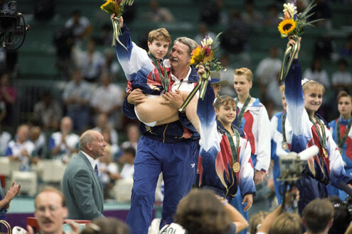 Béla Károlyi trägt Kerri Strug auf dem Arm